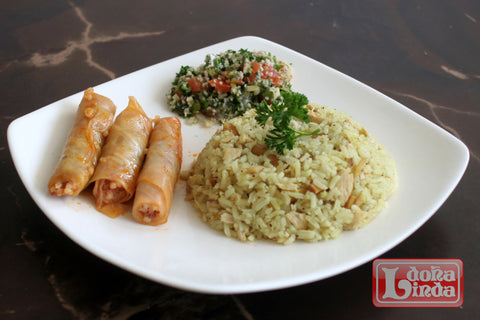 Plato de comida árabe con arroz de almendras, repollitos y tabbule